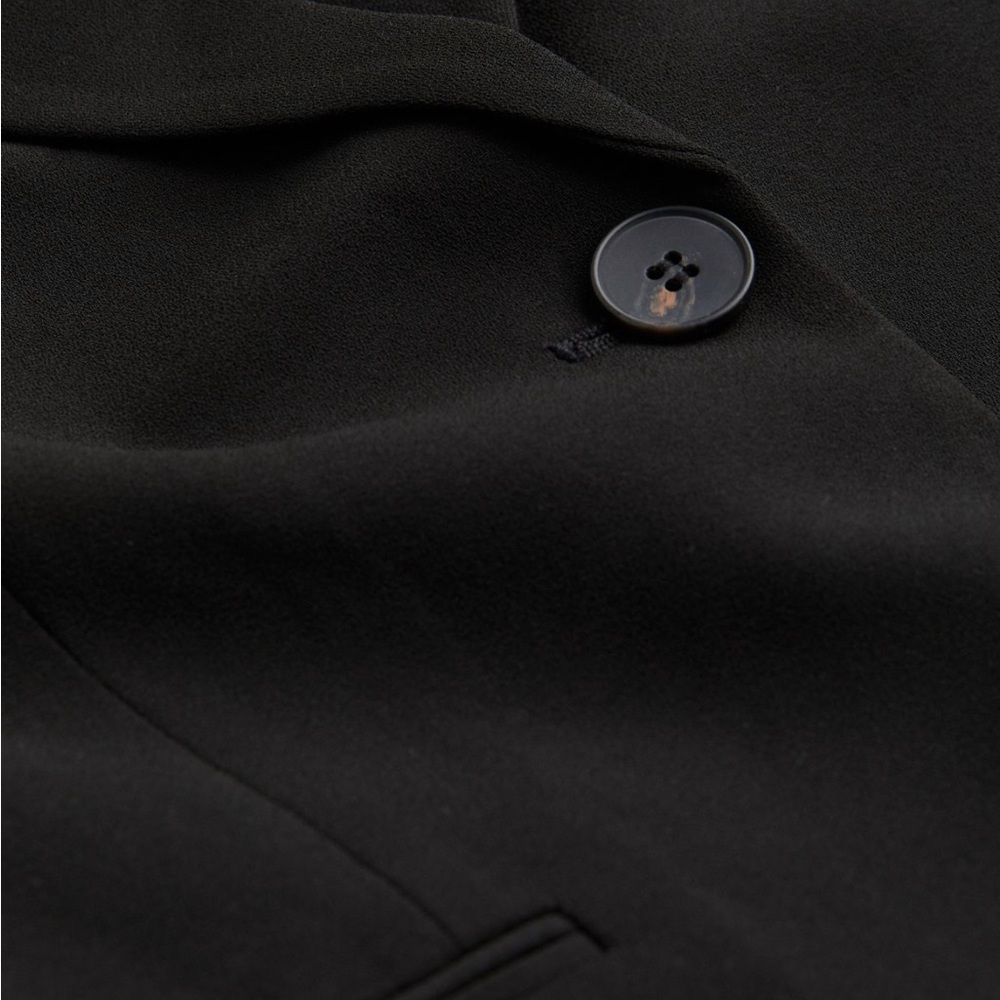 Black relaxed fit straight cut jacket.
